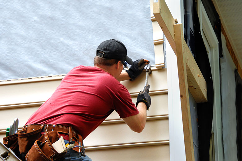 A person installing siding